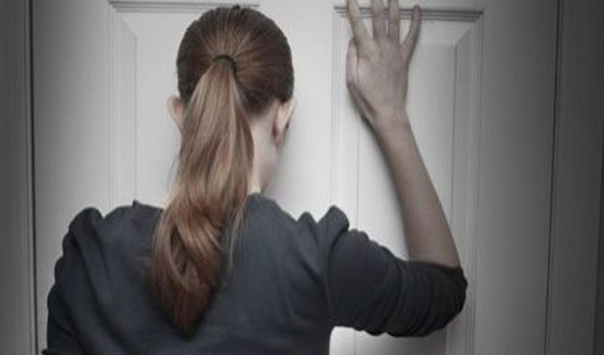 Vrouw staat voor een gesloten voordeur in Venlo Vrouw staat voor een gesloten voordeur in Venlo